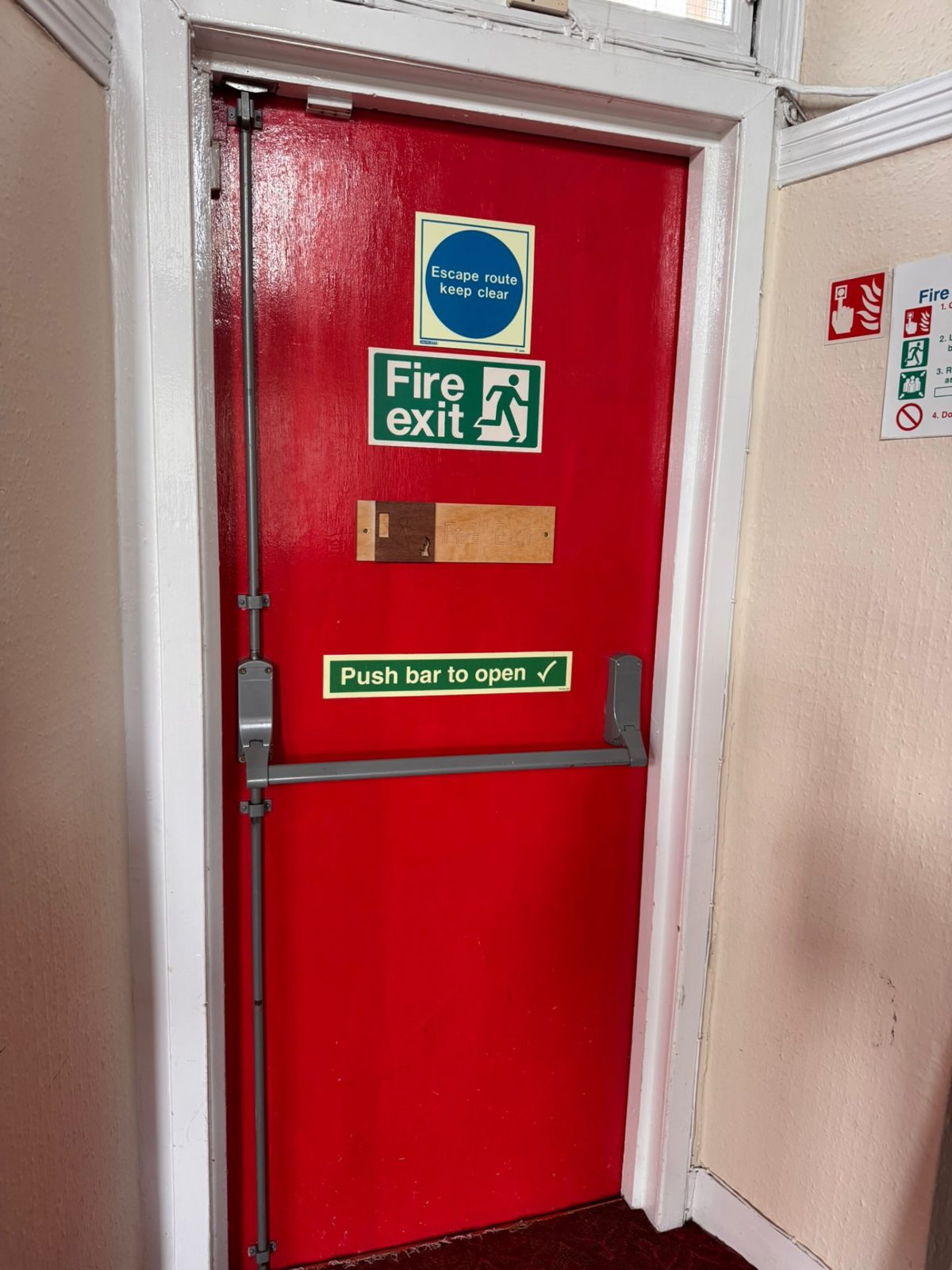 Fire exit door with push bar and escape route signage
