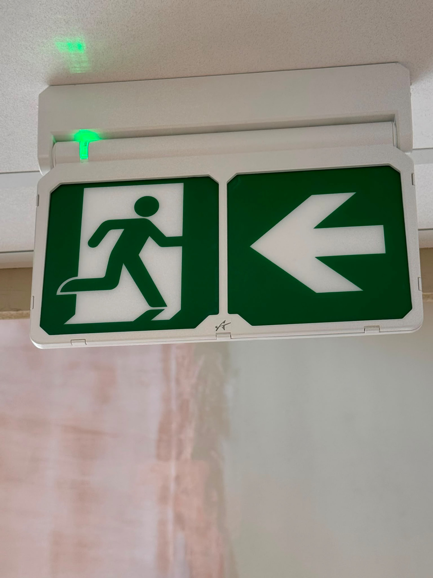 Illuminated emergency exit sign above an escape route in consulting premises